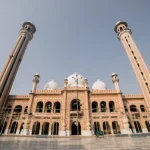A grand mosque with tall minarets and domes, featuring intricate architecture, supported by Giving Hands.