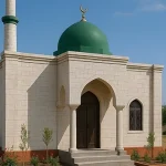 A small mosque with a green dome and single minaret, surrounded by greenery, supported by Giving Hands.