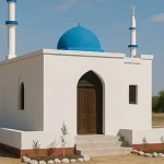 A small mosque with a blue dome and two minarets, set in a rural area, supported by Giving Hands.