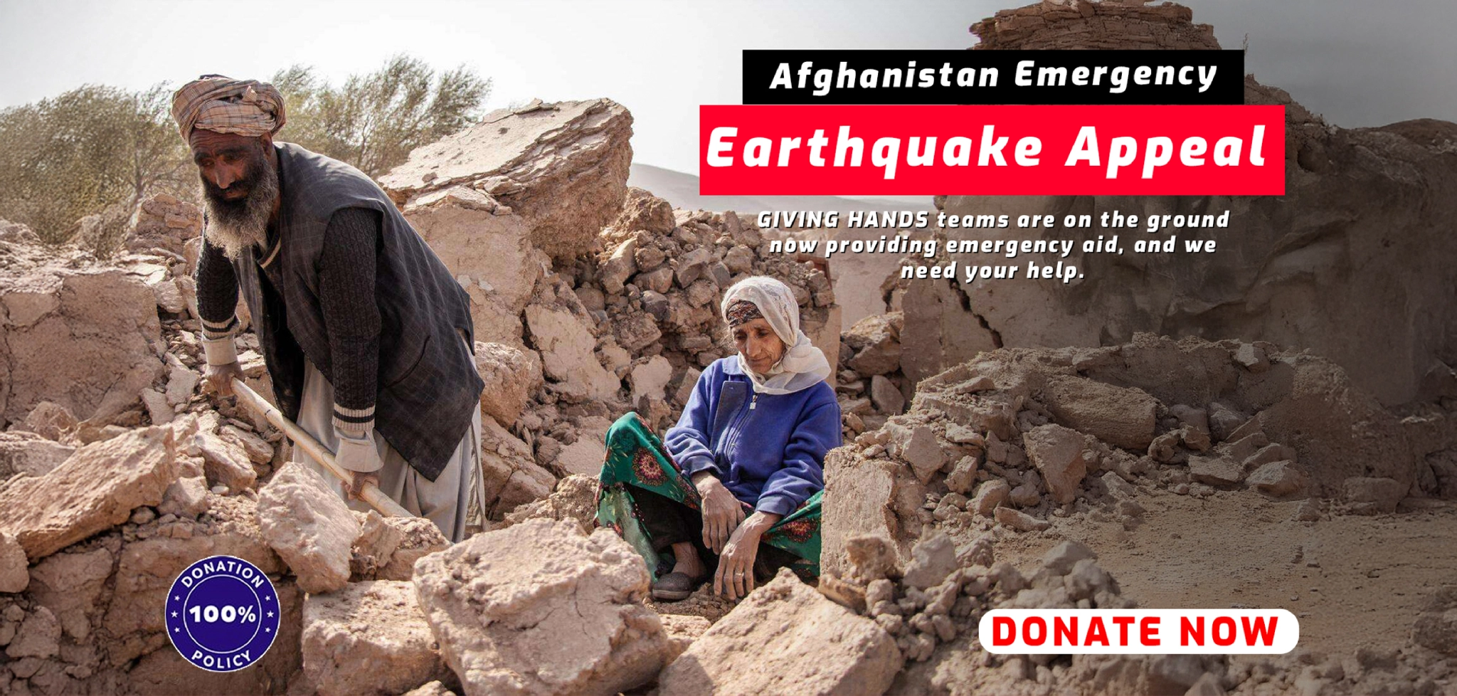 Two people among earthquake rubble with Afghanistan Emergency Earthquake Appeal banner.