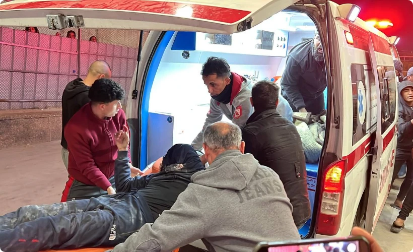 Paramedics and aid workers provide emergency medical assistance to an injured person being loaded into an ambulance.