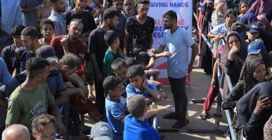 Crowd of people waiting in line at a Giving Hands food distribution point